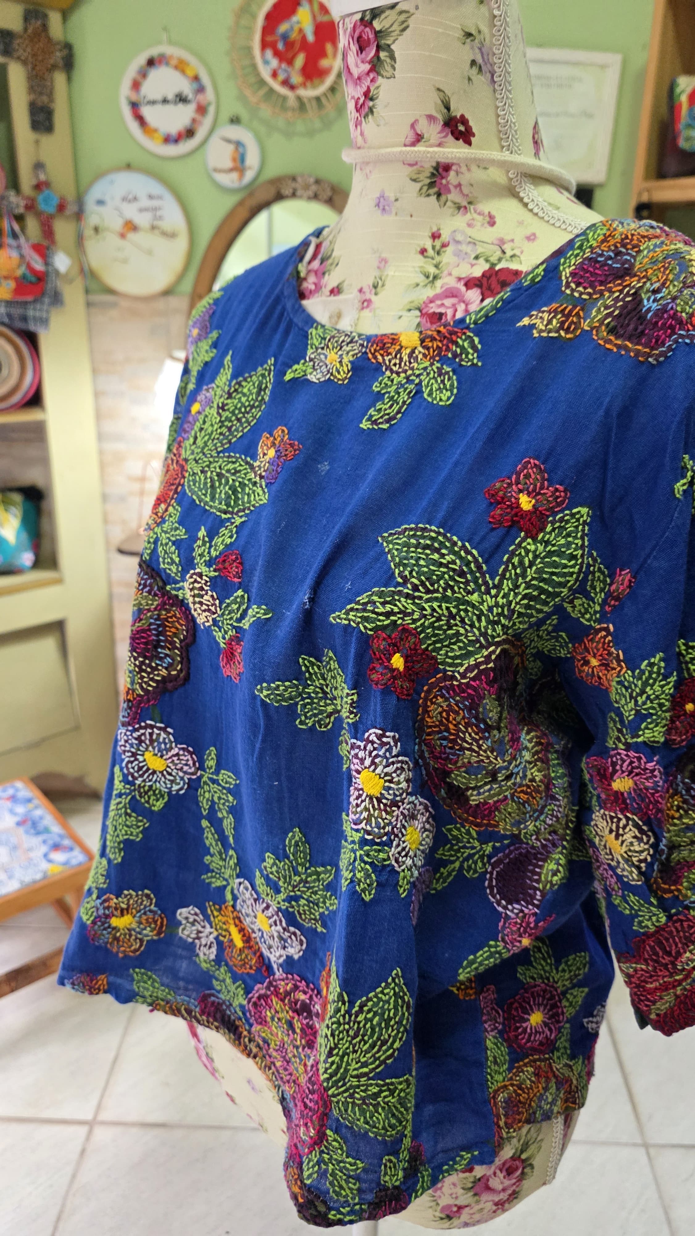 Blusa azul bordada em chita no manequim